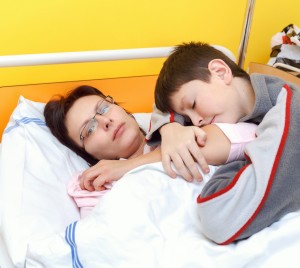 Woman with Glasses and Child on Hospital Bed